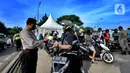 Petugas memeriksa identitas pengendara saat penerapan Pembatasan Sosial Berskala Besar (PSBB) pada check point di Jalan RE Martadinata, perbatasan dengan wilayah Bogor, Tangerang Selatan, Sabtu (18/4/2020). Hari ini Tangerang Raya melakukan  PSBB hingga 3 Mei 2020. (merdeka.com/Arie Basuki)
