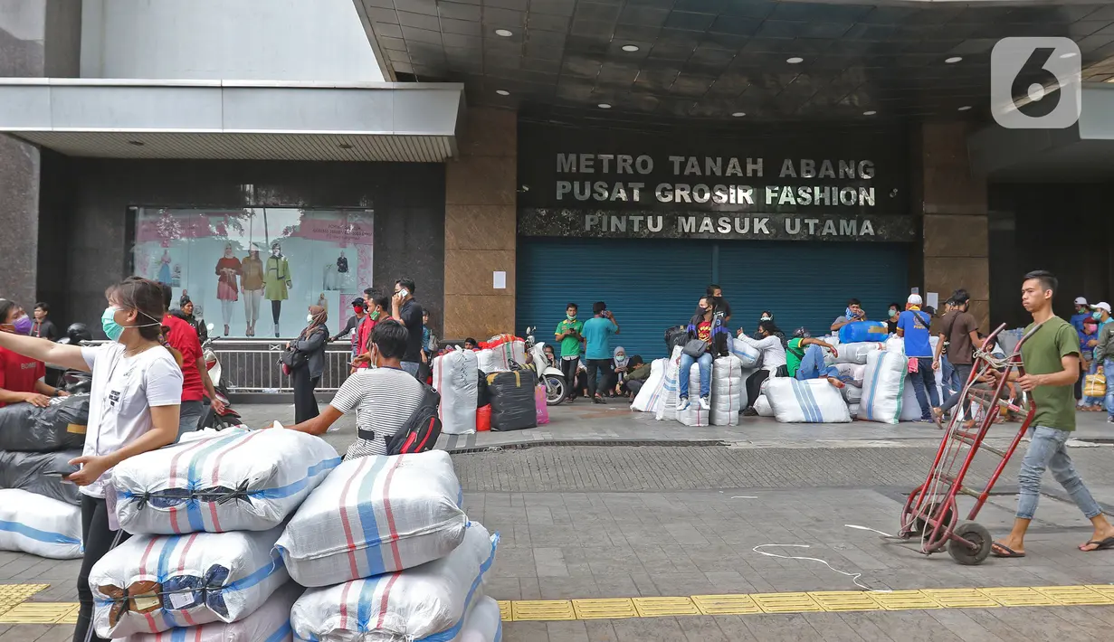 Aktivitas orang-orang di depan pintu masuk utama metro Tanah Abang yang tutup di Jakarta, Senin (6/4/2020). Pemerintah Provinsi DKI Jakarta memperpanjang penutupan sementara Pasar Tanah Abang hingga 19 April 2020 sebagai bentuk pencegahan penyebaran corona COVID-19. (Liputan6.com/Herman Zakharia)