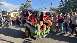 Pembalap tim Team HRC naik andong di Kota Sumbawa, NTB, Jumat (23/6/2023) menjelang balapan MXGP Sumbawa 2023 di Sirkuit Samota pada 24-25 Juni 2023. Tim HRC menurunkan dua crosser, Ruben Fernandes dan Tim Gajser. (Bola.com/Wiwig Prayugi)