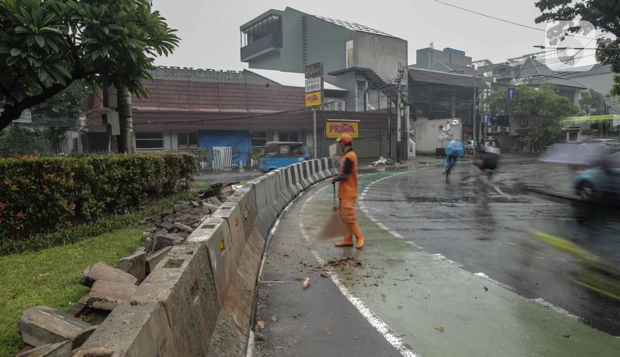 Petugas PPSU membersihkan sampah dekat beton pembatas di Jalan Senopati, Jakarta, Minggu (29/12/2019). Pascakejadian mobil tabrak Apotek Senopati, Suku Dinas Bina Marga memasangan beton pembatas untuk meminimalisir kejadian serupa terulang kembali. (Liputan6.com/Faizal Fanani)