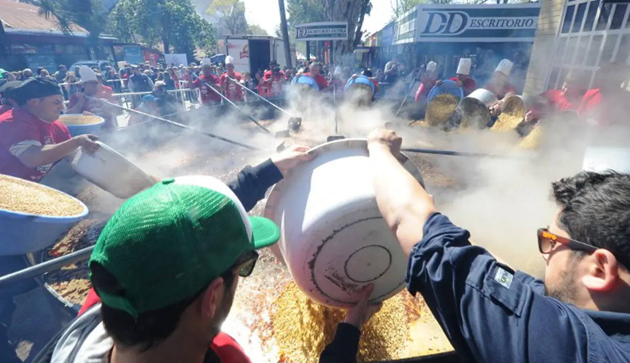 Koki saat menuangkan kacang lentil rebus di panci raksasa untuk memecahkan rekor dunia Guinness Record dalam acara Prado Rural di Montevideo, Uruguay, Minggu (13/9/2015). Kacang tersebut cukup untuk memberi makan 10.000 orang. (AFP PHOTO/Miguel Rojo)