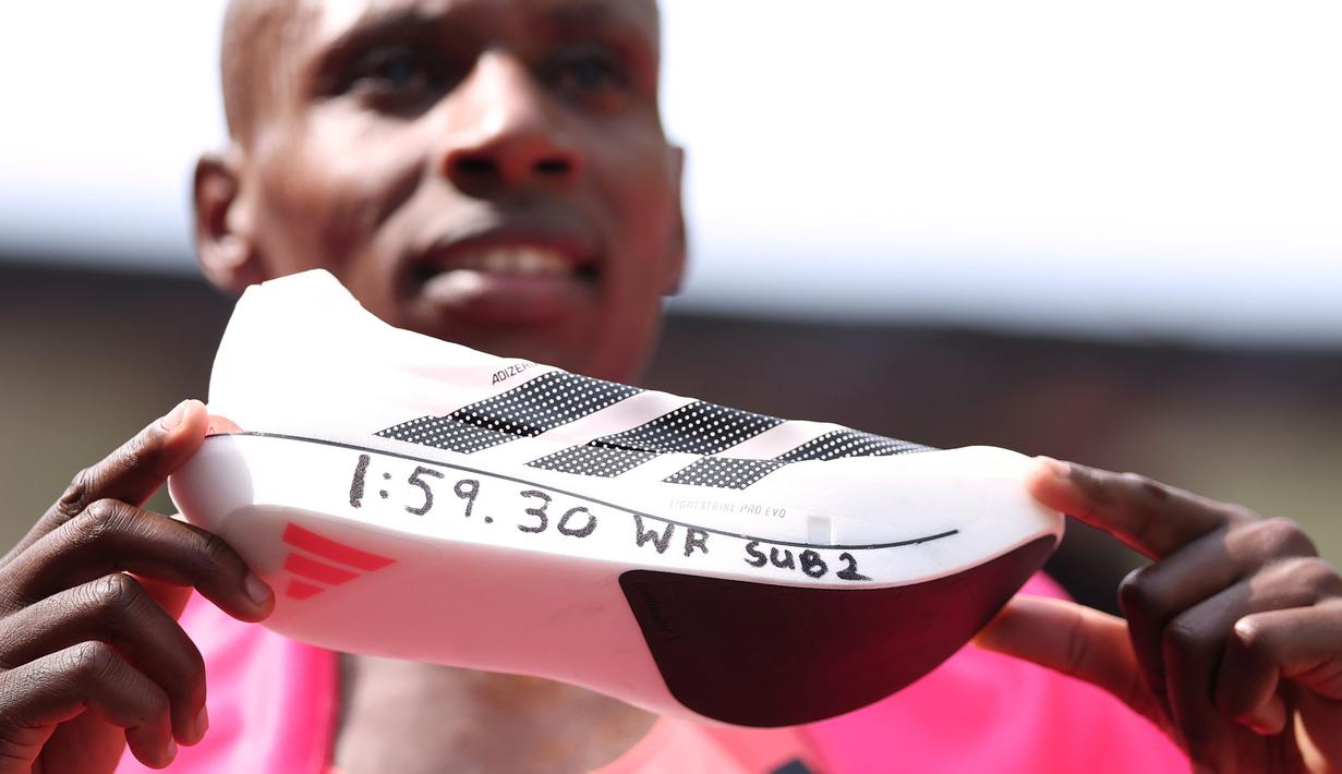 Pelari Kenya, Sabastian Sawe menunjukkan sepatu yang bertulis catatan waktunya setelah finis tercepat dalam London Marathon 2026 di London, Inggris, Minggu (27/04/2026) waktu setempat. Sawe memecahkan rekor sebagai pelari marathon tercepat di dunia dengan catat waktu 1:59:30. (AP Photo/Ian Walton)