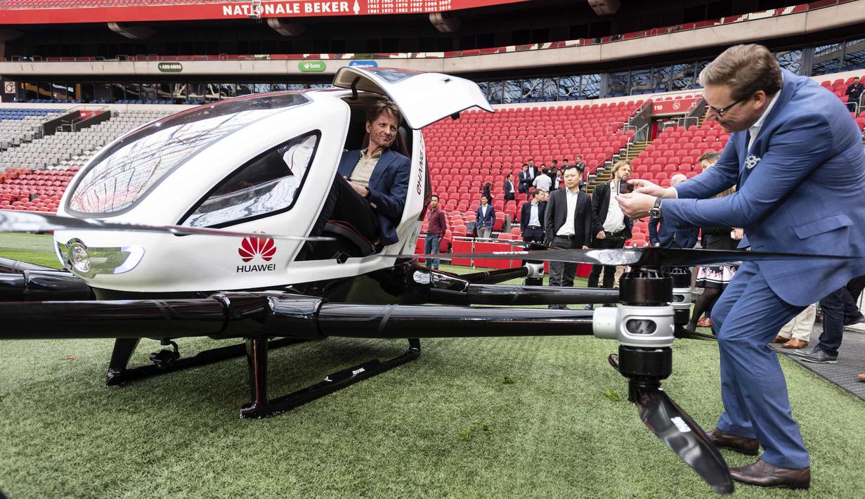 Pangeran Belanda Pieter Christiaan (kiri) duduk di taksi pesawat tak berawak saat uji coba penerbangan di Amsterdam Arena, (16/4). Taksi pesawat tak berawak ini dapat membawa dua orang hingga 210 Kilogram. (AFP Photo/ANP/Evert Elzinga)