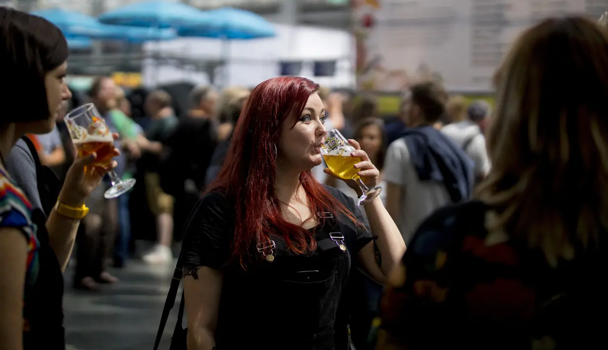 Seorang wanita menikmati minum bir selama The Great British Beer Festival di Kensington Olympia di London barat (6/8/2019). Great British Beer Festival tahunan ini diadakan 6-10 Agustus 2019. (AFP Photo/Tolga Akmen)