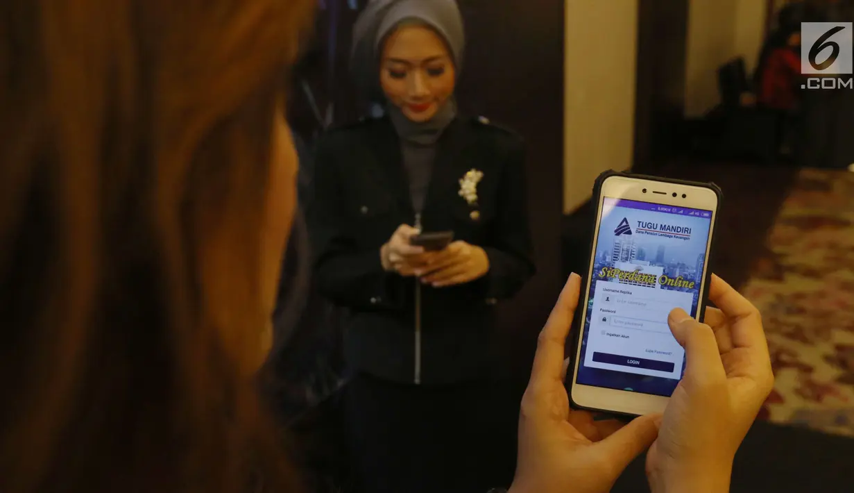 Model menunjukkan aplikasi mobile SIPerdana (System Informasi Peserta Dana Pensiun) PT Asuransi Jiwa Tugu Mandiri usai di luncurkan di Jakarta, Rabu (28/3). (Liputan6.com/Angga Yuniar)