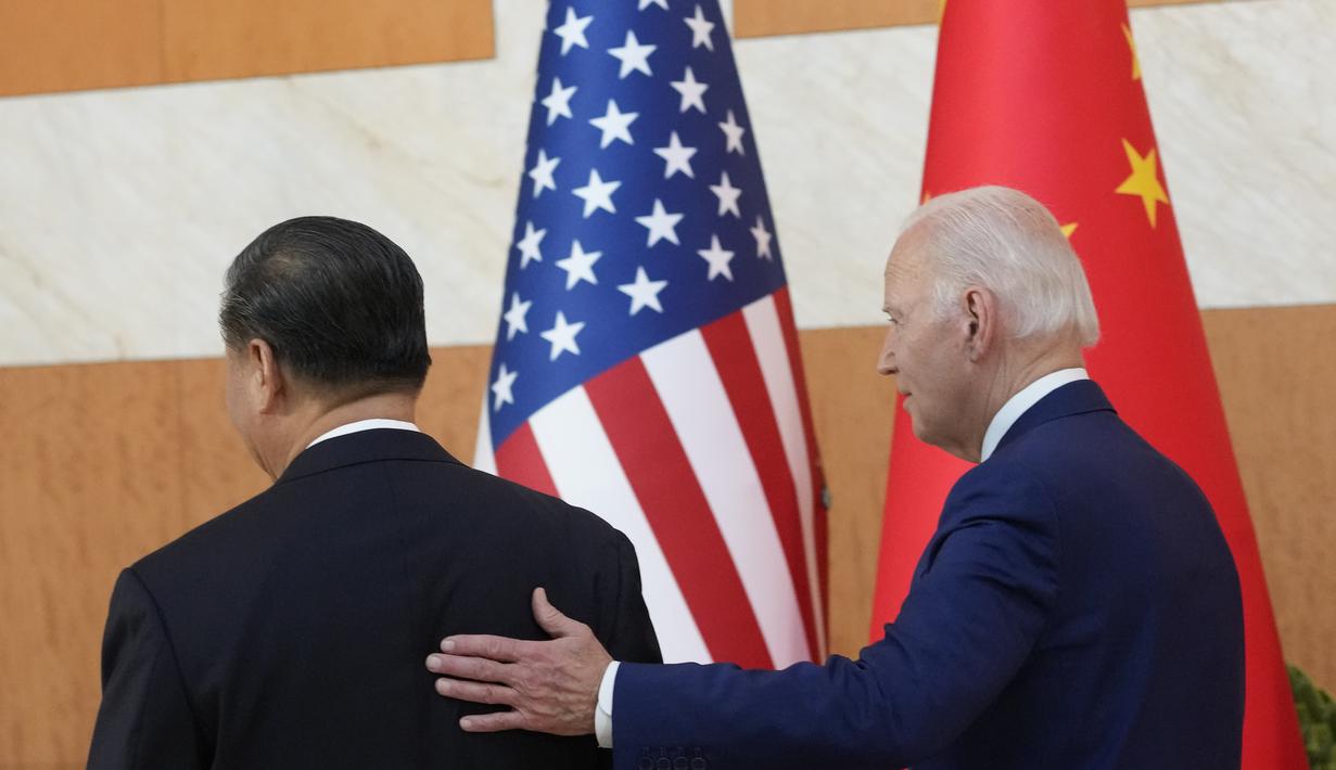 Presiden AS Joe Biden berjalan dengan Presiden China Xi Jinping sebelum pertemuan di sela-sela pertemuan puncak G20 di Nusa Dua, di Bali, Senin (14/11/2022). Pertemuan ini menjadi catatan sejarah di tengah panas dingin hubungan Amerika Serikat dan China. (AP/Alex Brandon)
