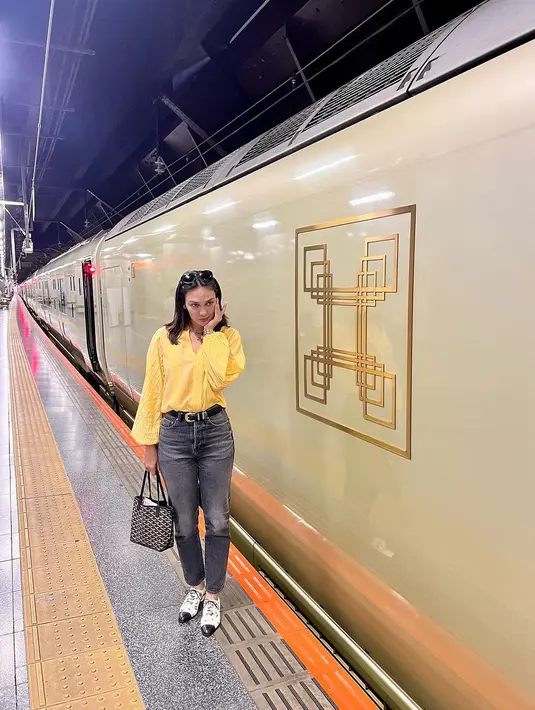 Gaya Luna Maya menjajal kereta luxury di Jepang. Ia mengenakan atasan lengan panjang berwarna kuning, dipadunya dengan celana jeans abu-abu. [Foto: Instagram/lunamaya]