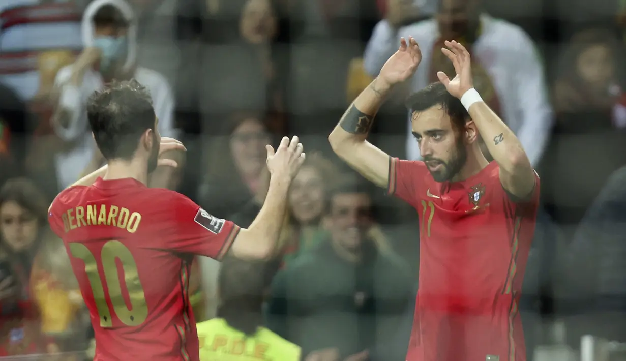 Gelandang Portugal Bruno Fernandes berselebrasi dengan Bernardo Silva setelah mencetak gol ke gawang Makedonia Utara pada playoff Kualifikasi Piala Dunia 2022 di Estadio Do Dragao, Rabu (30/3/2022) dinihari WIB. Portugal lolos usai menang 2-0 atas Makedonia Utara. (AP Photo/Luis Vieira)