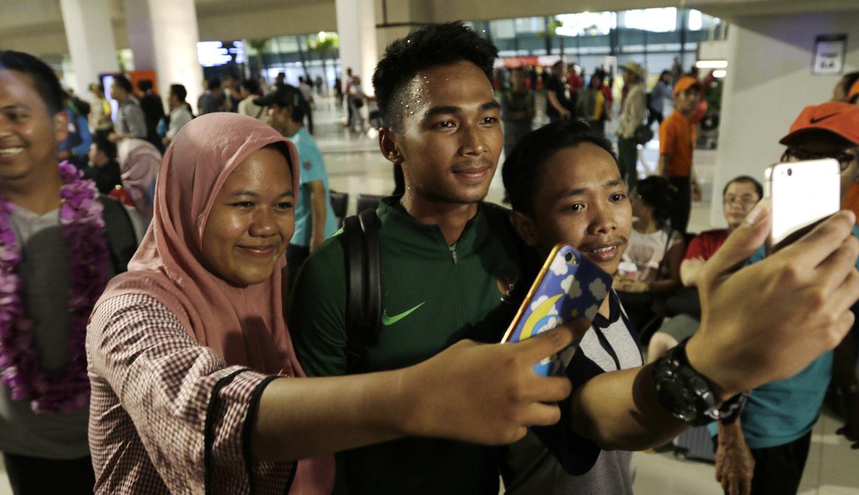 Warga mengajak selfie pemain Timnas Indonesia, Bagas Adi, usai menjadi juara Piala AFF U-22 2019 di Bandara Soetta, Tanggerang, Rabu (27/2). Timnas Indonesia mendapatkan bonus sebesar 2,1 milliar rupiah dari Kemenpora. (Bola.com/Yoppy Renato)