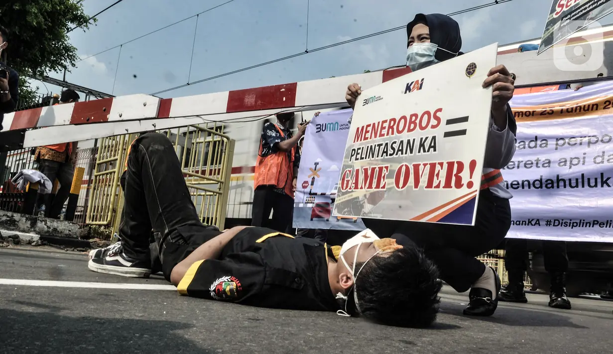 Aksi teatrikal sosialisasi keselamatan di perlintasan kereta api sebidang, Kemayoran, Jakarta, Rabu (14/10/2020). PT KAI Daop 1 menggelar sosialisasi dan aksi teatrikal dalam rangka meningkatkan kesadaran pengendara saat melintasi perlintasan sebidang. (merdeka.com/Iqbal Nugroho)