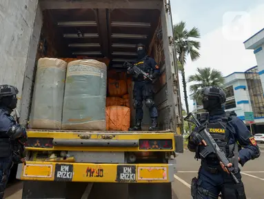 Petugas Direktorat Jenderal Bea dan Cukai (DJBC) Kementerian Keuangan menunjukkan barang bukti pakaian bekas selundupan di Jakarta, Rabu (11/3/2020). DJBC menyita 874 ballpress pakaian bekas yang diangkut delapan truk tronton. (merdeka.com/Imam Buhori)