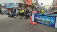 Sejumlah petugas kepolisian tengah mengamanka sejumlah rute di pusat perkotaan Jl. Jenderal Ahmad Yani, Garut, Jawa Barat dalam penerapan sistem ganjil-genap saat PPKM level 3 di Garut. (Liputan6.com/ Jayadi Supriadin)