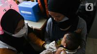 Petugas menyuntikan anak imunisasi di RPTRA Pola Idaman, Pondok Labu, Jakarta Selatan, Senin (1/8/2022). Sebanyak 76 anak mengikuti bulan imunisasi anak nasional pemberian imunisasi tambahan Campak-Rubela dan pemberian imunisasi pada anak yang belum mendapatkan imunisasi lengkap. (Liputan6.com/Herman Zakharia)