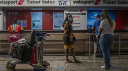 Penumpang menunggu di loket tiket di bandara Johannesburg OR Tambo, Afrika Selatan (29/11/2021). Banyak negara memberlakukan larangan penerbangan terhadap negara-negara Afrika selatan karena kekhawatiran atas varian baru (Covid-19) Omicron. (AP/Jerome Delay)