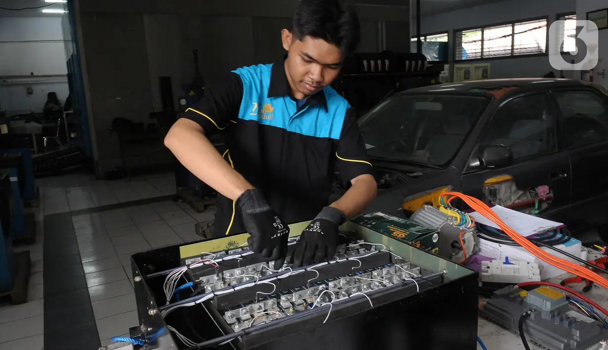 Pelajar SMK Negeri 26 Jakarta melakukan pengecekan instalasi part konversi mobil listrik di Bengkel Otomotif SMKN 26, Jakarta, Rabu (13/5/2023). (merdeka.com/Imam Buhori)