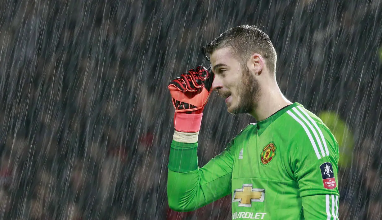  Kiper Manchester United,  David De Gea mengusap wajah dari guyuran air hujan pada laga Piala FA melawan Sheffield United di Old Trafford, Minggu (10/1/2016) dini hari WIB.  (Reuters/Jason Cairnduff)
