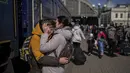 Seorang ibu memeluk putranya yang melarikan diri dari kota Mariupol yang terkepung dan tiba di stasiun kereta api di Lviv, pada 20 Maret 2022. Pada Hari 25 perang Rusia di Ukraina, kehidupan yang kacau, perpisahan yang pahit tertangkap dalam foto-foto Associated Press. (AP Photo/Bernat Armangue)