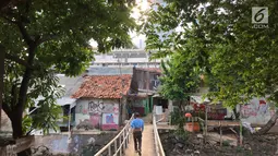 Seorang warga menyebrangi jembatan di daerah kumuh di kawasan Kuningan, Jakarta, Jumat (2/2). Pemprov DKI Jakarta akan menurunkan 1 persen angka kemiskinan dalam 5 tahun Pemerintah Anies-Sandi. (Liputan6.com/Immanuel Antonius)