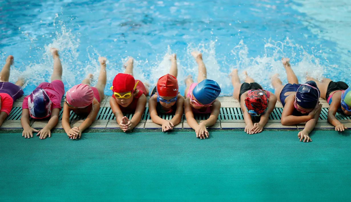 Sejumlah anak melakukan pemanasan sebelum latihan berenang di sekolah Hangzhou Chen Jinglun Sport sekolah Natatorium, Hangzhou, provinsi Zhejiang, China, (10/8). Sekolah ini pernah melatih perenang Olimpiade Sun Yang dan Fu Yuanhui. (REUTERS/Aly Song)