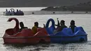 Sejumlah pasukan Taliban saat menaiki perahu kayuh di Danau Qargha di sebuah pekan raya di Kabul barat (28/9/2021). Mereka mengaku datang ke danau ini untuk bersenang-senang. (AFP/Wakil Kohsar)