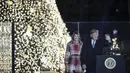 Presiden AS, Donald Trump dan ibu negara Melania Trump menghadiri upacara penerangan pohon cemara, yang menjadi Pohon Natal Nasional di taman sebelah selatan Gedung Putih, Kamis (5/12/2019). Pohon Natal Nasional tahun ini adalah cemara biru segar dari Colorado. (Drew Angerer/Getty Images/AFP)