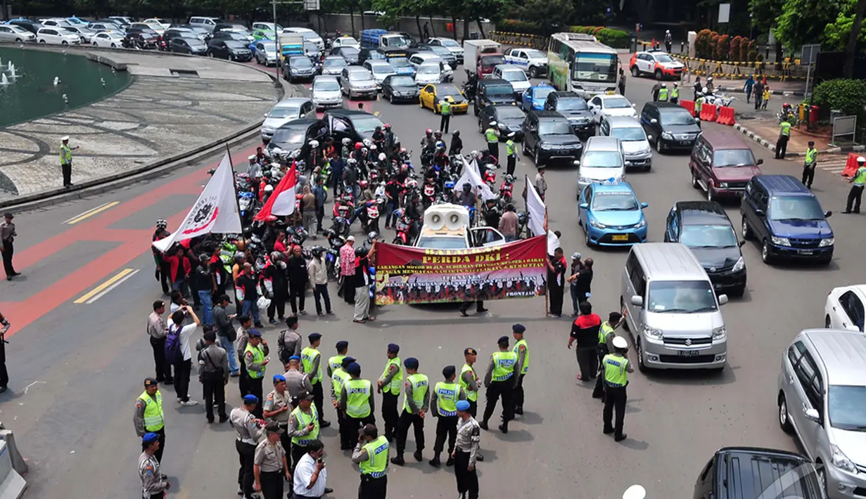 Petugas kepolisian saat menghadang para pengendara motor yang mencoba untuk masuk ke jalan MH Thamrin,  Jakarta, Minggu (22/12/2014). (Liputan6.com/Johan Tallo)