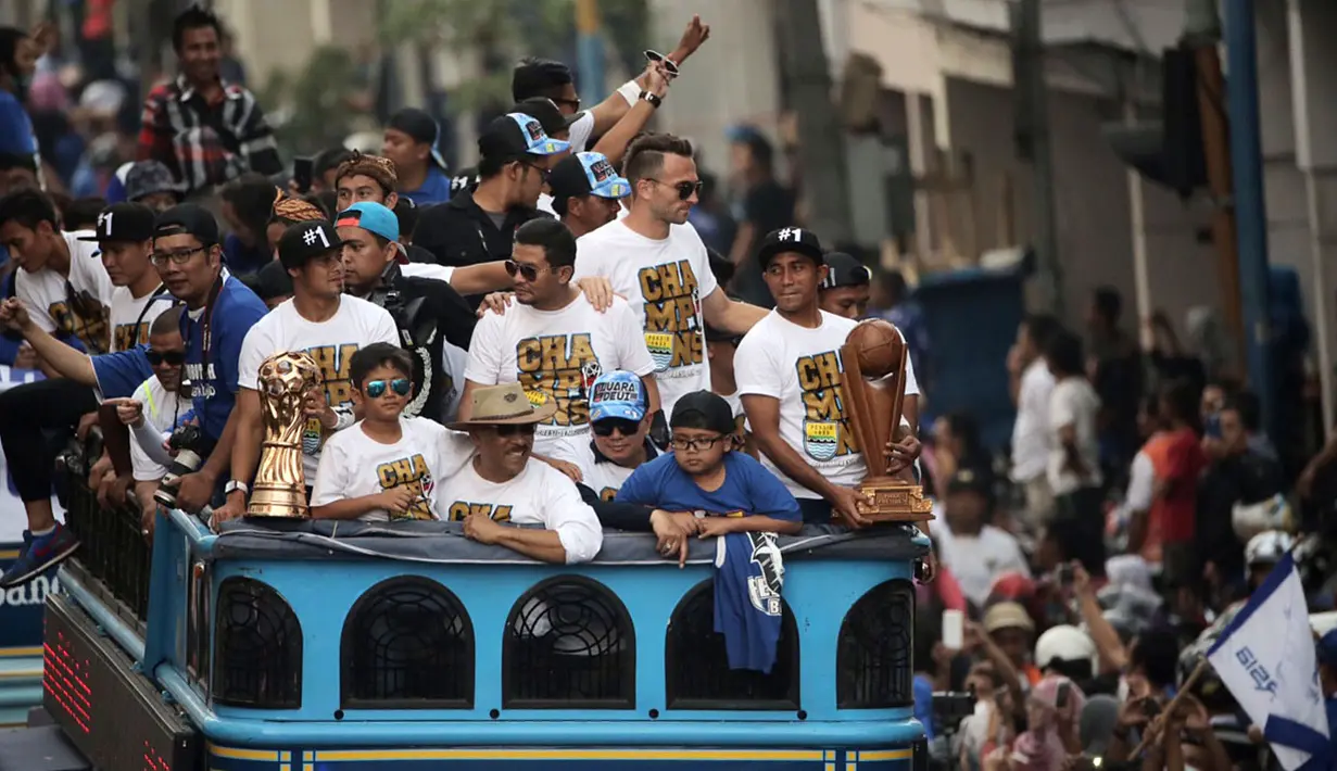 Pemain Persib, Firman Utina, memegang trofi Piala Presiden saat berlangsungnya Pawai Persib Juara Piala Presiden di jalanan kota Bandung, Minggu (25/10/2015). (Bola.com/Nicklas Hanoatubun)