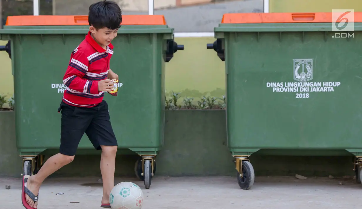 Anak-anak pencari suaka bermain sepak bola di halaman bekas Markas Kodim di Kalideres, Jakarta, Selasa (16/7/2019).  Sejak Kamis (11/7) para pencari suaka dipindahkan dari di pinggir jalan dan trotoar di kawasan Kebon Sirih ke bekas Markas Kodim di Kalideres . (Liputan6.com/Helmi Fithriansyah)