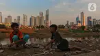 Anak anak bermain dengan latar gedung bertingkat di Jakarta, Jumat (15/12/2023). (Liputan6.com/Angga Yuniar)