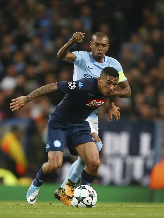 Gelandang Manchester City, Fernandinho, berusaha merebut bola dari gelandang Napoli, Allan, pada laga Liga Champions di Stadion Etihad, Selasa (17/10/2017). Manchester City menang 2-1 atas Napoli. (AP/Dave Thompson)