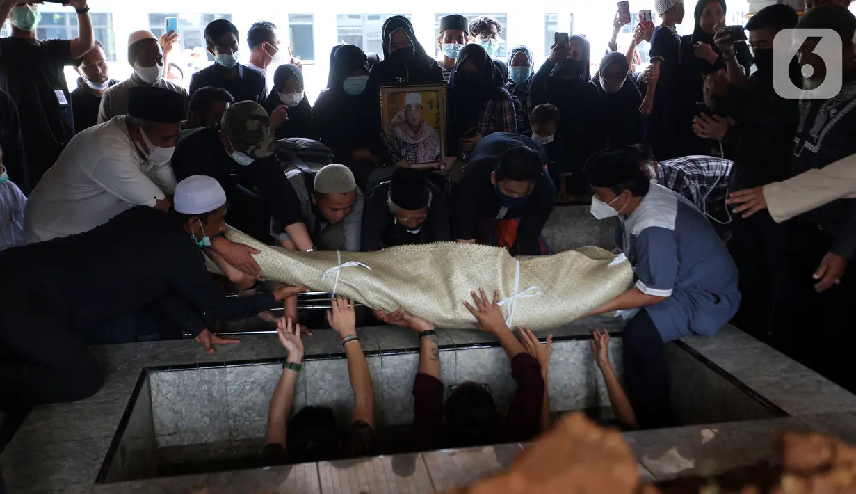 Pendakwah Ramdhan Effendi atau Anton Medan dimasukkan ke liang lahat saat pemakaman di area Masjid Tan Kok Liong, Pondok Rajeg, Cibinong, Bogor, Jawa Barat, Selasa (16/3/2021). Anton Medan mengembuskan napas terakhir pada 15 Maret 2021. (Kapanlagi.com/Budy Santoso)
