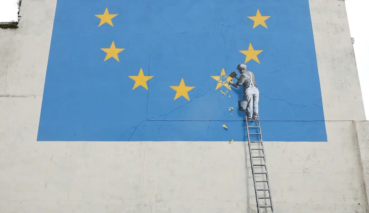 Warga mengamati mural yang menggambarkan seorang pria tengah menghancurkan salah satu dari 12 bintang kuning bendera Uni Eropa di dinding kawasan Dover, Inggris, Senin (8/5). Mural karya seniman jalanan Banksy itu berjudul 'Brexit'. (Gareth Fuller/via AP)