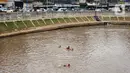 Anak-anak berenang di aliran Sungai Ciliwung, Jatinegara, Jakarta Timur, Sabtu (4/7/2020). Minimnya lahan bermain menyebabkan anak-anak tersebut bermain tidak pada tempatnya, meski dapat membahayakan keselamatan. (Liputan6.com/Immanuel Antonius)