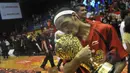 Pemain Satria Muda Britama Erick Sebayang kegirangan mencium piala NBL Indonesia 2015 usai mengalahkan Pelita Jaya Energi-MP, Jakarta, Minggu (10/5/2015). Satria Muda Britama unggul 62-54 atas Pelita Jaya Energi-MP. (Liputan6.com/Herman Zakharia)