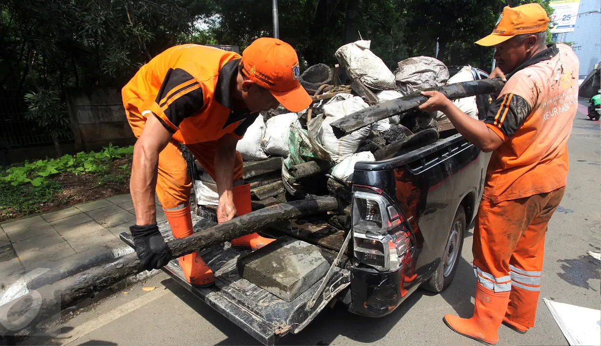 Petugas menggunakan mobil pick up untuk mengangkut kulit kabel yang ditemukan di gorong-gorong saluran air Jalan Gatot Subroto, Jakarta, Senin (6/3). Tumpukan kulit kabel ini dianggap menjadi penyebab utama terjadinya banjir. (Liputan6.com/Johan Tallo)