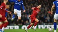 Gelandang Liverpool, Takumi Minamino menggiring bola dari kawalan para pemain Everton pada pertandingan babak ketiga Piala FA di Anfield, Minggu (5/1/2020). Pemain Jepang menjalani debut bersama Liverpool dengan menjadi starter dipertandingan tersebut. (AFP/Paul Ellis)