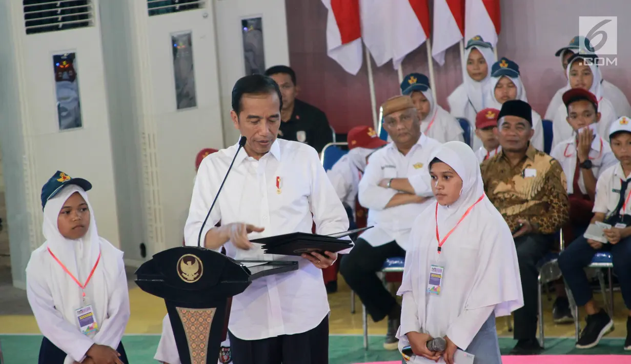 Presiden Jokowi memberikan hasil cetak foto kepada salah satu siswa pada acara penyerahan Kartu Indonesia Pintar (KIP) bagi 4.000 siswa-siswi SD, SMP, SMA se Provinsi Gorontalo di GOR David-Tonny, Gorontalo Jumat (1/3). (Liputan6.com/Arfandi Ibrahim)