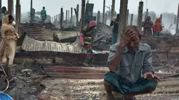 Seorang pengungsi Rohingya yang tampak sedih melihat tempat tinggalnya ludes terbakar saat musibah kebakaran melanda kamp pengungsi Nayapara di Cox's Bazar, Bangladesh (14/1/2021). Tidak ada laporan korban jiwa akibat kebakaran ini. (AP Photo/Mohammed Faisal)