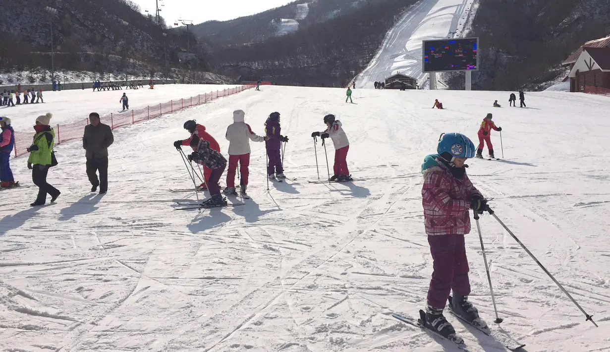 Anak-anak sekolah Korea Utara bersiap untuk bermain ski di resor ski Masik Pass (28/1). Resor ski ini dibangun pada tahun 2013 atas perintah pemimpin Korea Utara Kim Jong Un. (AP Photo / Eric Talmadge)