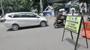 Kendaraan melintasi papan imbauan saat penindakan Pembatasan Sosial Berskala Besar (PSBB) di kawasan Menteng, Jakarta, Senin (13/4/2020). (merdeka.com/Iqbal S. Nugroho)