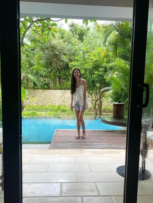 Saat honeymoon di Bali, Mikha tentu tampil bergaya khas gadis tropis. Seperti tank top putih dengan ruffle dan shorts. [@miktambayong]