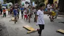 Anak-anak membawa carrucha saat mengikuti lomba jalanan tradisional "carruchas", sebutan untuk mobil kayu darurat di Caracas, Venezuela, Sabtu (18/12/2021). Anak-anak menikmati perlombaan yang menandai 10 tahun melestarikan tradisi ini. (AP Photo/Ariana Cubillos)