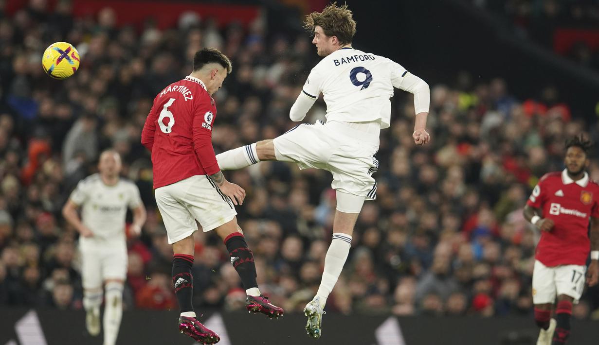 Pemain Leeds United, Patrick Bamford, menendang pemain Manchester United, Lisandro Martinez pada laga Liga Inggris di Stadion Old Trafford, Rabu (8/2/2023). Kedua tim bermain sama kuat dengan skor 2-2. (AP Photo/Dave Thompson)