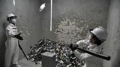Seorang pria memukul botol yang dilempar di "rage room" atau ruang kemarahan di Singapura (19/10). Tempat ini disediakan untuk para karyawan yang ingin melampiaskan hari buruk mereka dan stres karena tekanan di kantor. (AFP Photo/Roslan Rahman)