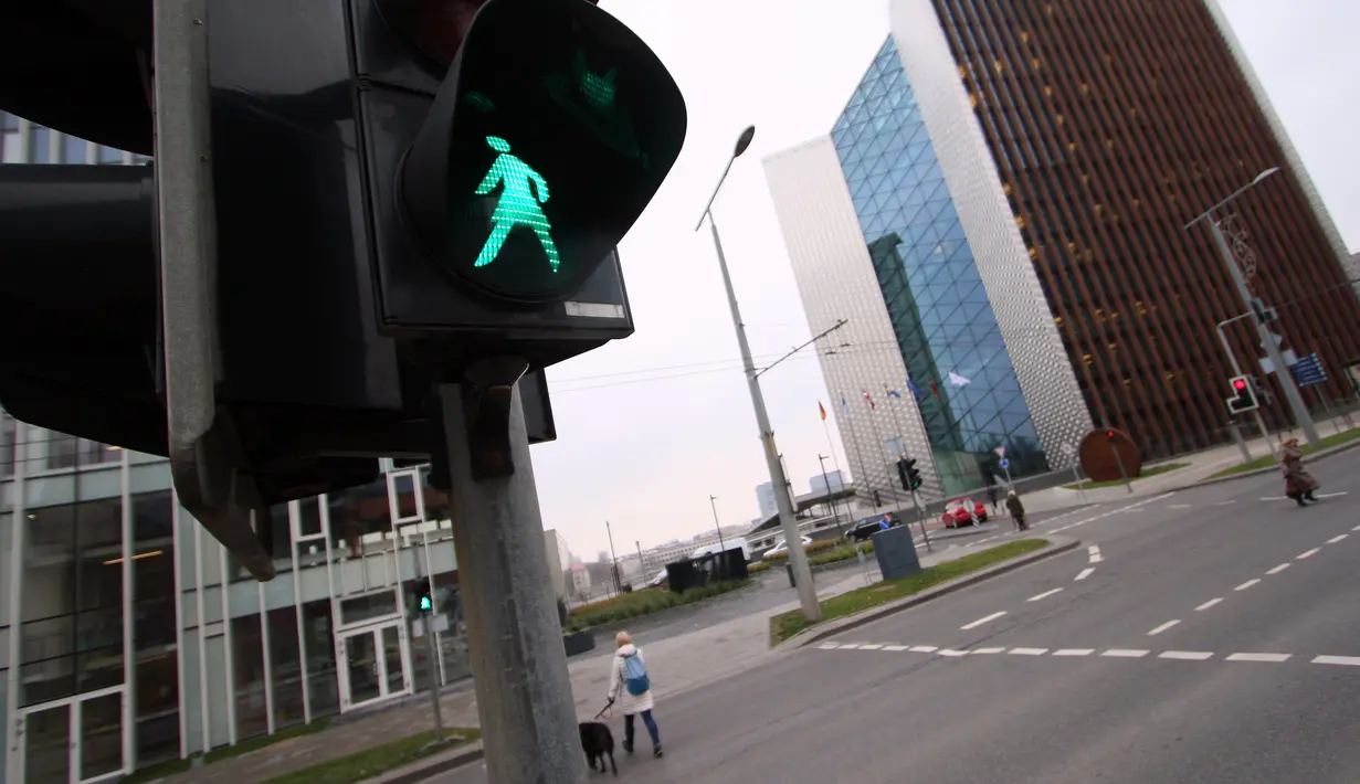 Lampu lalu lintas khusus pejalan kaki yang menampilkan simbol wanita di Vilnius, Lituania, Jumat (2/11). Hal itu untuk merayakan ulang tahun ke-100 wanita memperoleh pengakuan internasional dalam pemungutan suara di negara baltik. (Petras Malukas/AFP)