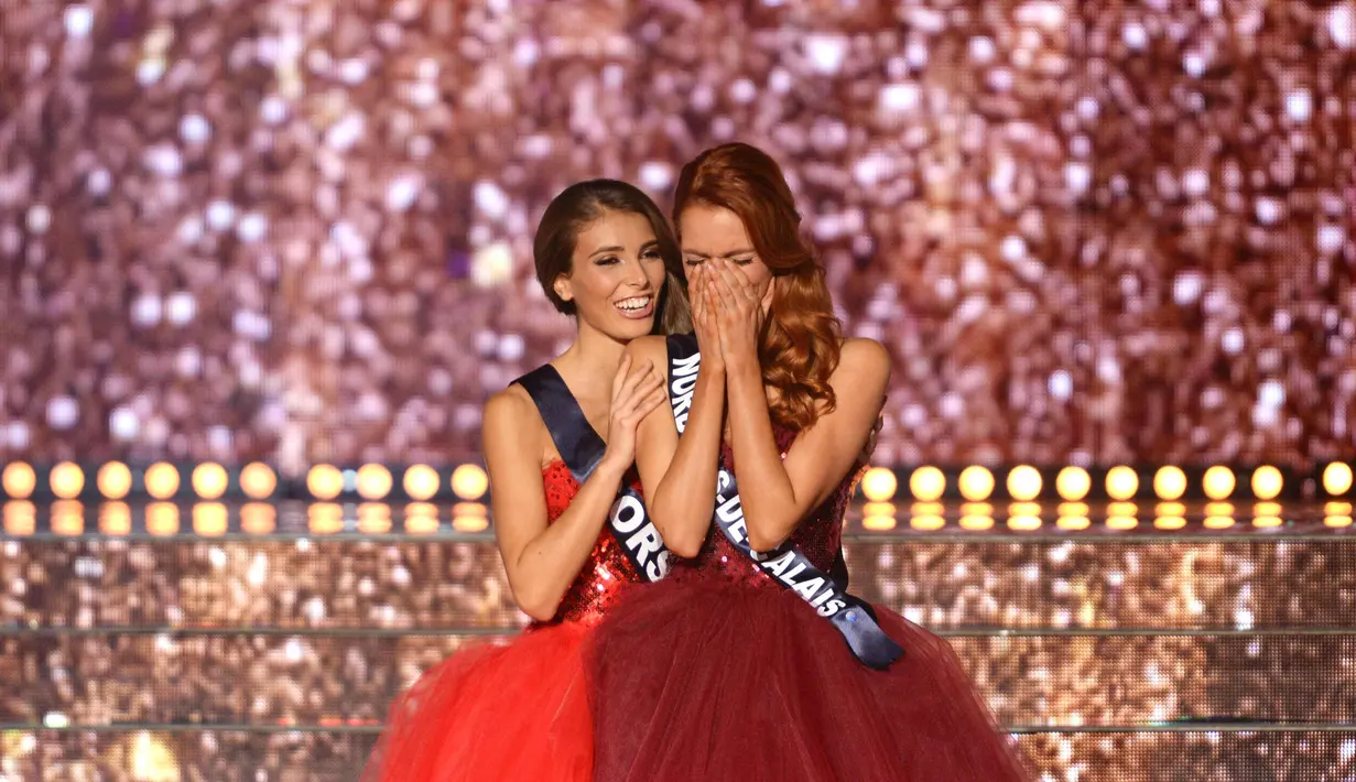 Maeva Coucke (kanan) menutupi wajahnya setelah dinobatkan sebagai Miss France 2018 di Chateauroux, Prancis tengah (16/12). Pada tanggal 23 September 2017 Coucke dinobatkan sebagai Miss Nord-Pas-de-Calais 2017. (AFP Photo/Guillaume Souvant)