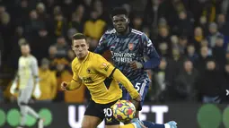 Pemain Wolverhampton Wanderers, Daniel Podence membawa bola dari kawalan pemain Arsenal, Thomas Partey selama pertandingan lanjutan Liga Inggris di stadion Molineux di Wolverhampton, Inggris, Jumat (11/2/2022). Arsenal menang tipis atas Wolverhampton Wande 1-0. (AP Photo/Rui Vieira)