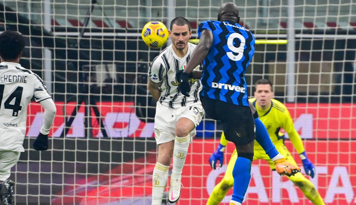 Striker Inter Milan, Romelu Lukaku melepaskan tendangan yang dihalangi bek Juventus, Leonardo Bonucci dalam laga lanjutan Liga Italia Serie A 2020/21 pekan ke-18 di San Siro Stadium, Minggu (17/1/2021). Inter Milan menang 2-0 atas Juventus. (AFP/Miguel Medina)