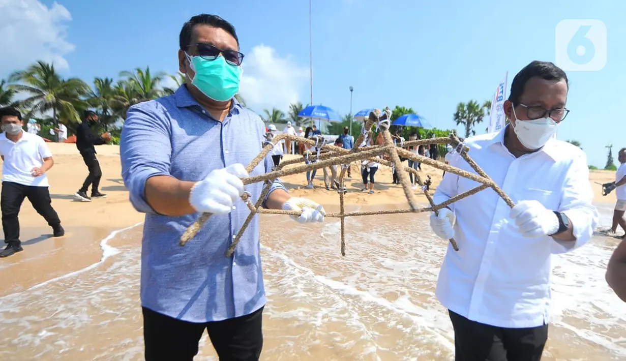Direktur Utama PT Bank Tabungan Negara (Persero) Tbk. Haru Koesmahargyo dan Anggota Komisi XI DPR RI Eriko Sotarduga membawa terumbu karang di pantai Nusa Dua, Denpasar Sabtu (10/4/2021). Sebanyak 710 terumbu karang di pasang di pantai Nusa Dua Bali. (Liputan6.com/Pool/BTN)