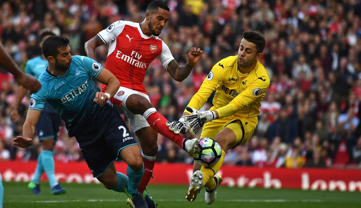 Theo Walcott (tengah) memborong dua gol saat Arsenal mengalahkan Swansea City 3-2 pada laga Premier League pekan ke-8 di Emirates Stadium, London (15/10/2016). (AFP/Justin Tallis)